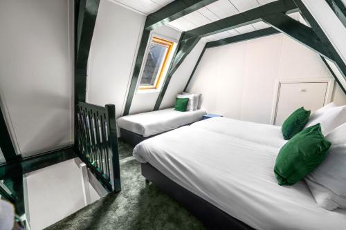 a bedroom with a large bed and a chair at Hotel des Arts in Amsterdam