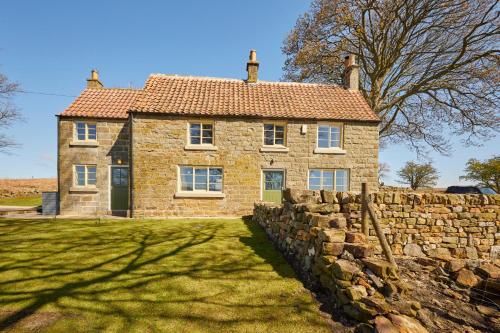an old stone house with a stone wall at Host & Stay - Lop Hall in Danby