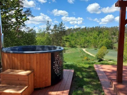 a large wooden tub sitting on a deck with a yard at Sielski Domek Na Wzgórzu in Sulęczyno