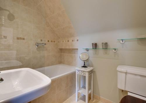 a bathroom with a tub and a sink and a toilet at The Barn Studio in Benenden
