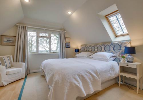 a bedroom with a white bed and a white chair at The Barn Studio in Benenden