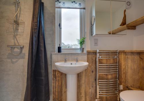 bagno con lavandino, servizi igienici e finestra di The Bolthole a Biddenden