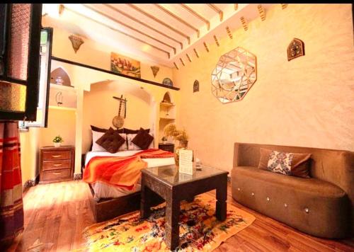 a bedroom with a bed and a couch in a room at Riad Maison Aicha in Marrakech