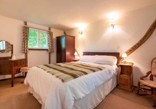 a bedroom with a large bed and a window at The Bothy in Biddenden