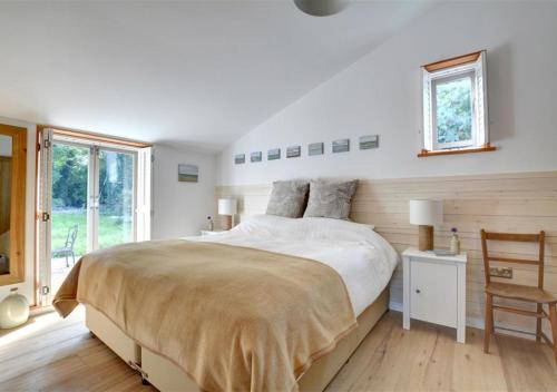 a bedroom with a large bed and a window at The Hideaway in Eastry