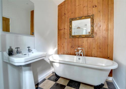 a bathroom with a white tub and a sink at The Hideaway in Eastry