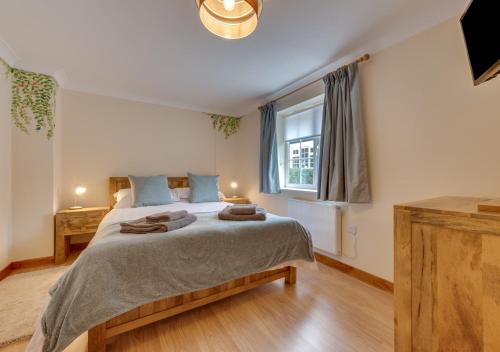 a bedroom with a large bed and a window at The Honey Pot in Lyminge