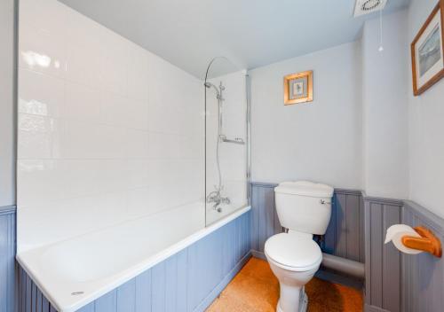 uma casa de banho com um WC e um chuveiro em The Little House em Rolvenden