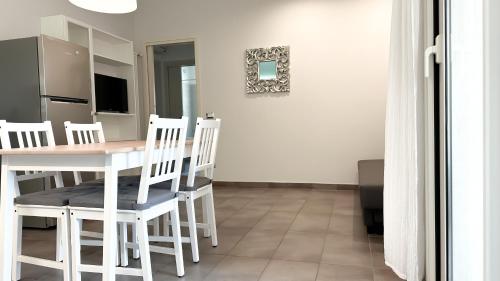 kuchnia i jadalnia ze stołem i krzesłami w obiekcie Appartamento Tagliamento 13 - Affitti Brevi Italia w mieście Riccione