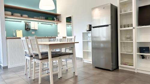 a kitchen with a table and a refrigerator at Appartamento Tagliamento 13 - Affitti Brevi Italia in Riccione