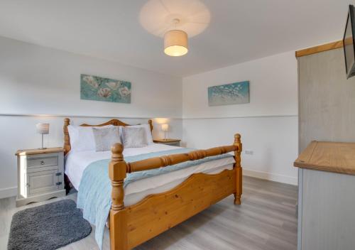 a bedroom with a wooden bed with a night stand at The Pump House in Hernehill