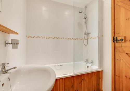 a bathroom with a white sink and a shower at The Old Granary in Brede