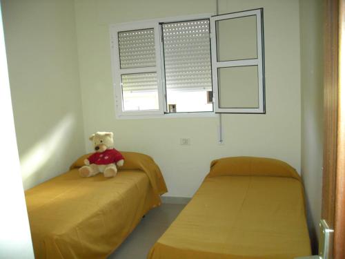 un osito de peluche sentado en dos camas en una habitación en Casa Gomera Mercedes, en San Sebastián de la Gomera