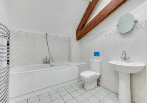 a bathroom with a tub sink and a toilet at Valley View Barn in Hartfield