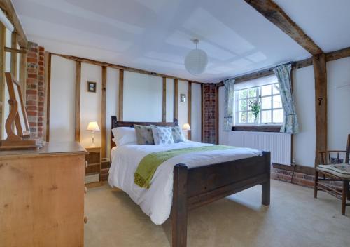 a bedroom with a large bed and a window at Wagon Lodge at Forstal Farm in Tenterden
