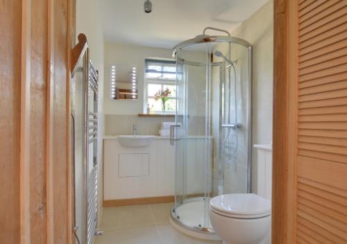 a bathroom with a shower and a toilet and a sink at Wagon Lodge at Forstal Farm in Tenterden