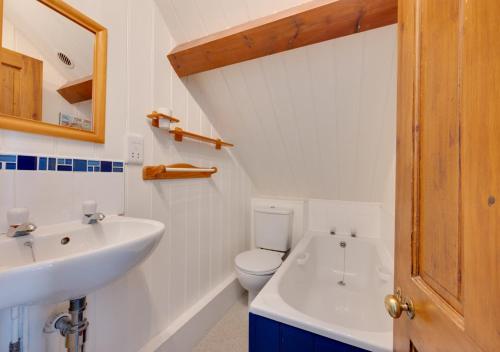 a white bathroom with a sink and a toilet at Umballa in Herne Bay