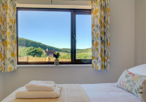 a bedroom with a bed and a large window at Valley View in Upper Hardres