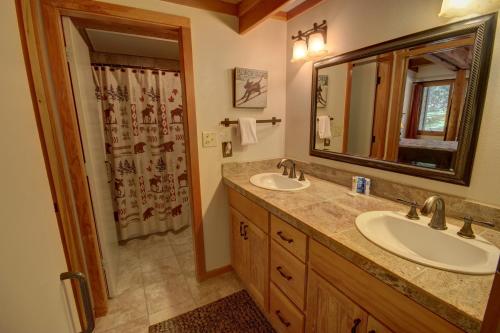 a bathroom with two sinks and a large mirror at Homestead 2031 in Keystone