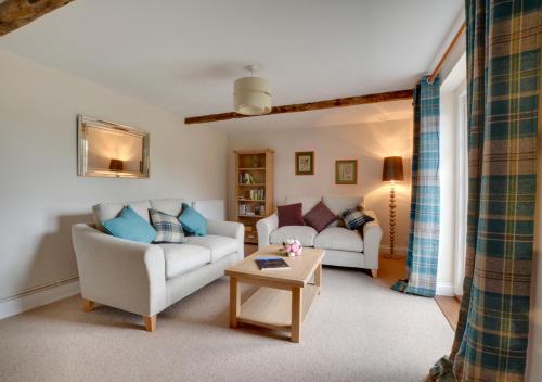 a living room with two couches and a table at Well Cottage in Barham