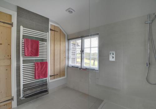 a bathroom with a shower and a glass shower stall at Well Cottage in Barham
