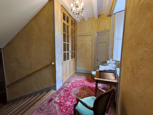 Zimmer mit einer Treppe, einem Stuhl und einem Tisch in der Unterkunft Suite dans un château dans le Haut Anjou in Pouancé