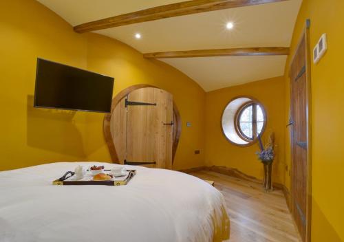 a bedroom with a bed with a tv on the wall at Vineyard Hollow in Bodiam