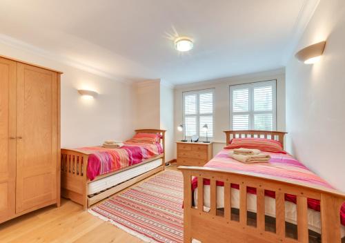um quarto com 2 camas e uma janela em York Mansions Apartment em Broadstairs