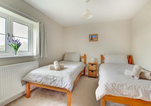 1 dormitorio con 2 camas individuales y ventana en Walnut Cottage, en Swingfield