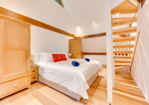 a bedroom with a bed and a staircase at Waterside Lodge in Bodiam