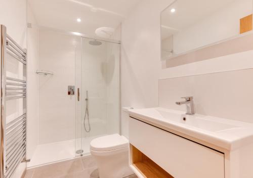 a white bathroom with a sink and a shower at Waterside Lodge in Bodiam