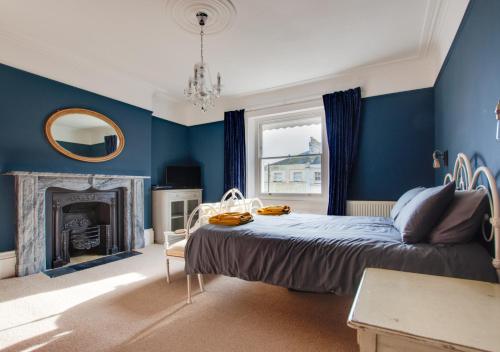 a blue bedroom with a bed and a fireplace at West Ascent in Hollington