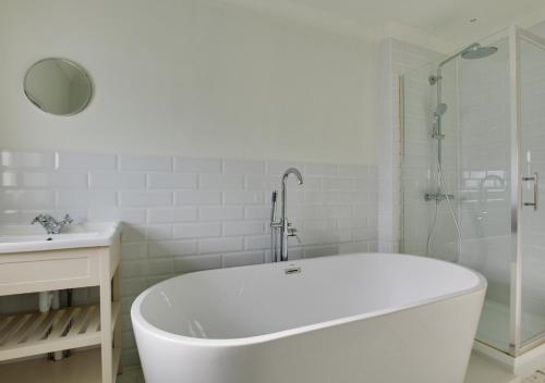 a white bathroom with a tub and a sink at West Ascent in Hollington