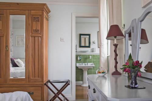 - une chambre avec un lavabo et un grand miroir dans l'établissement Sheriff Lodge, à Matlock