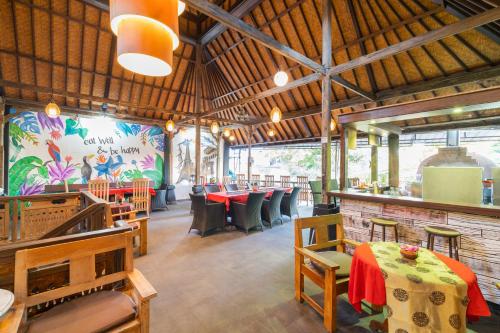 un ristorante con tavoli, sedie e un murale di Bamboo Ubud Hostel ad Ubud