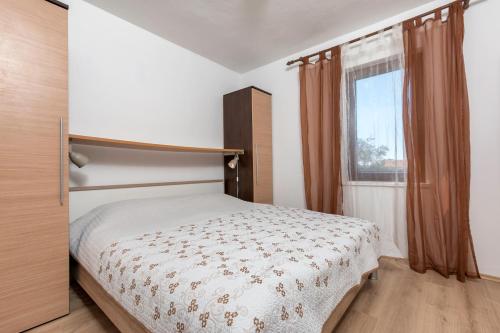 een kleine slaapkamer met een bed en een raam bij Apartments Mandić in Pula