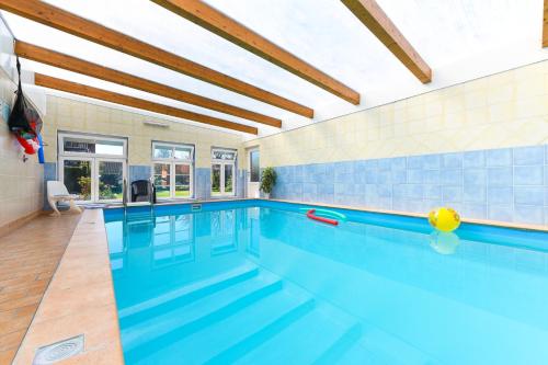 a large swimming pool with blue tile walls at Ferienwohnung im Haus Leemreize in Blomberg