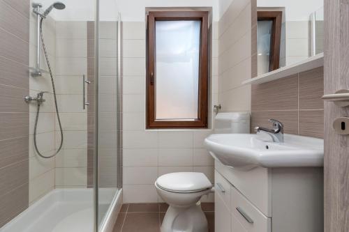een badkamer met een toilet, een wastafel en een douche bij Apartments Mandić in Pula