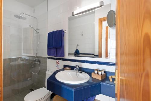 La salle de bains est pourvue d'un lavabo bleu et de toilettes. dans l'établissement Callao Beach 1, à Arrieta