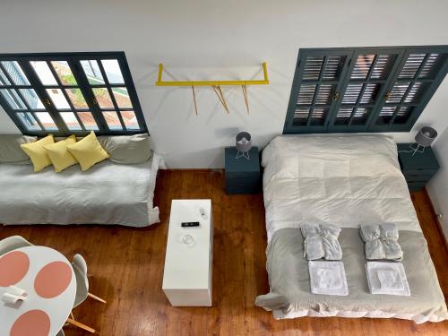 a room with two beds and a table and two windows at Departamento Excelente Ubicación. Zona Arístides y Parque. in Mendoza