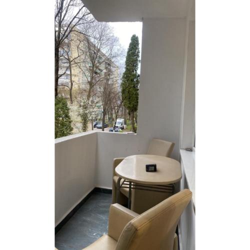 une chambre avec une table, des chaises et une fenêtre dans l'établissement Vidalis Suite, à Cluj-Napoca