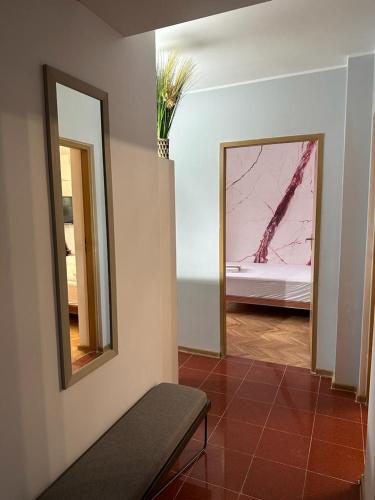 Cette chambre comprend un miroir et un lit. dans l'établissement Vidalis Suite, à Cluj-Napoca