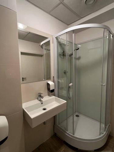 a bathroom with a sink and a glass shower at Aleja "Solidarności" in Warsaw