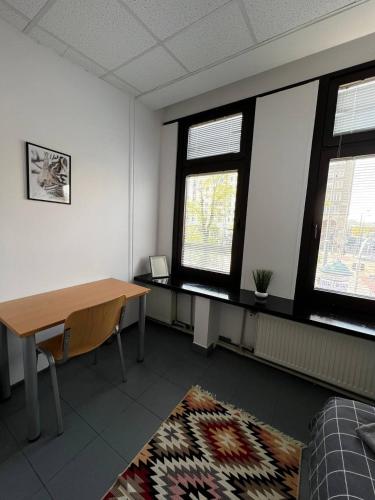 an office room with a desk and two windows at Aleja "Solidarności" in Warsaw