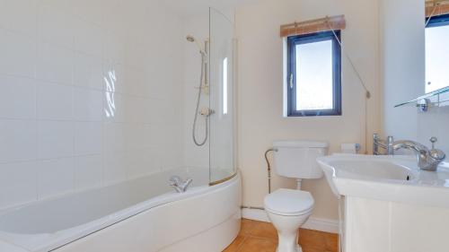 a bathroom with a toilet and a tub and a sink at Elm Croft in Old Brampton