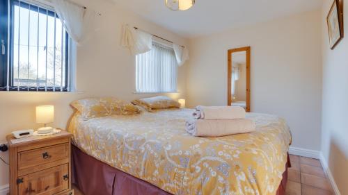 a bedroom with a bed with two towels on it at Elm Croft in Old Brampton