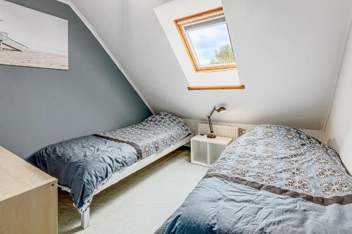 a bedroom with two beds and a window at Colibri 2 met parking in Nieuwpoort