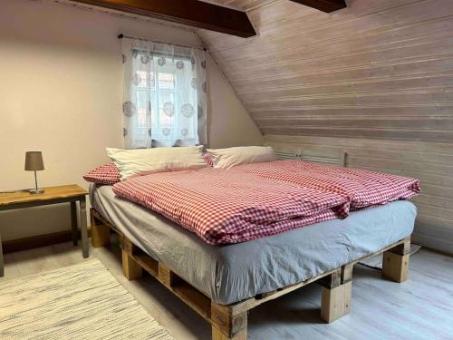 uma cama grande num quarto com uma janela em Maisonette-FeWo Fritz mit Infrarotsauna em Grosschönau