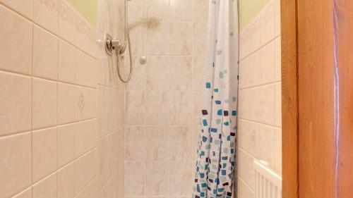 y baño con ducha y cortina de ducha. en Wayside Cottage en Tansley