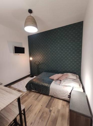 1 dormitorio con 1 cama con pared verde en Studio Le pigeonnier en Tallard